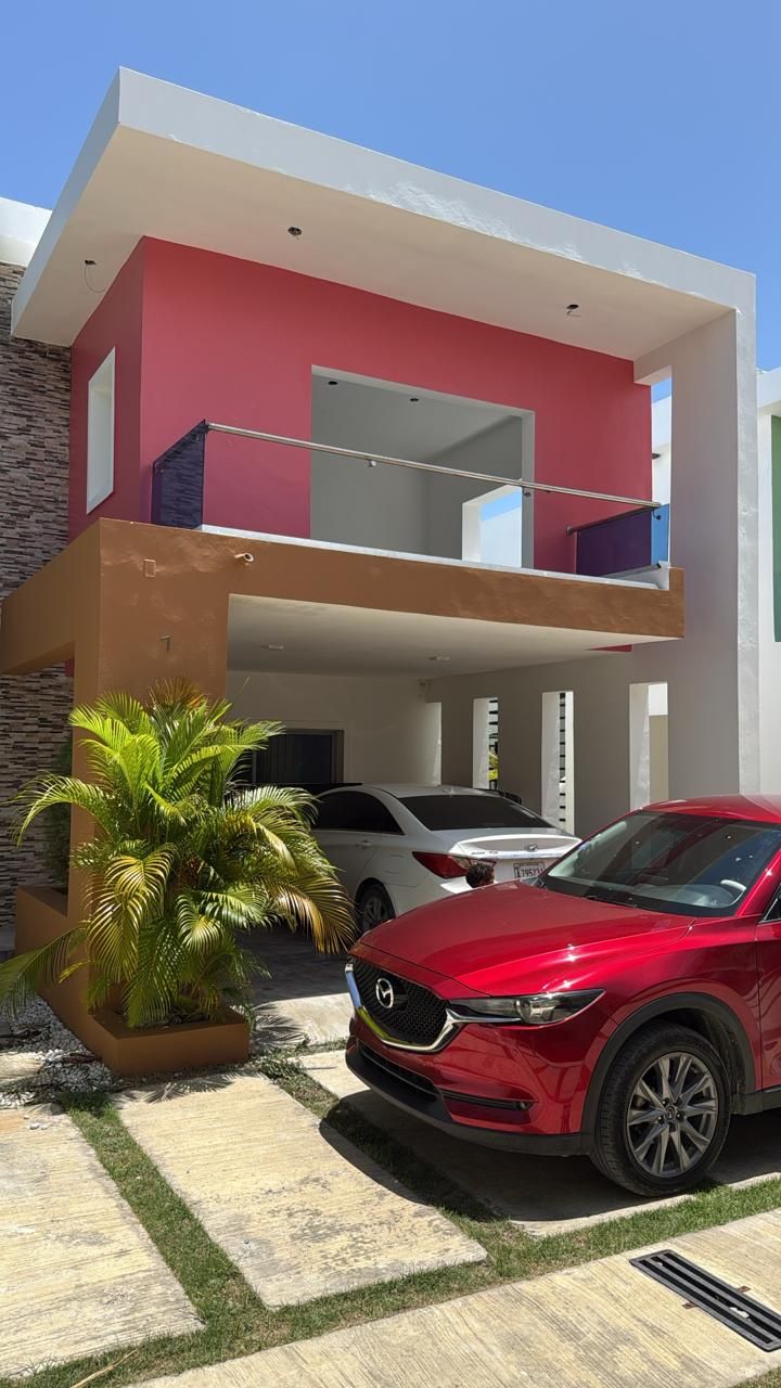 Casa reparada con fachada pintada en rojo, terracota y blanco