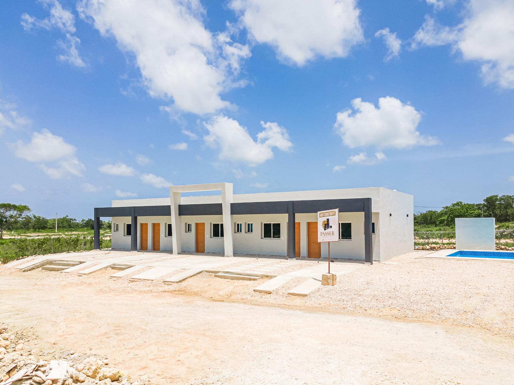 Bloque de townhouses con puertas de madera y letrero de PASSER SRL