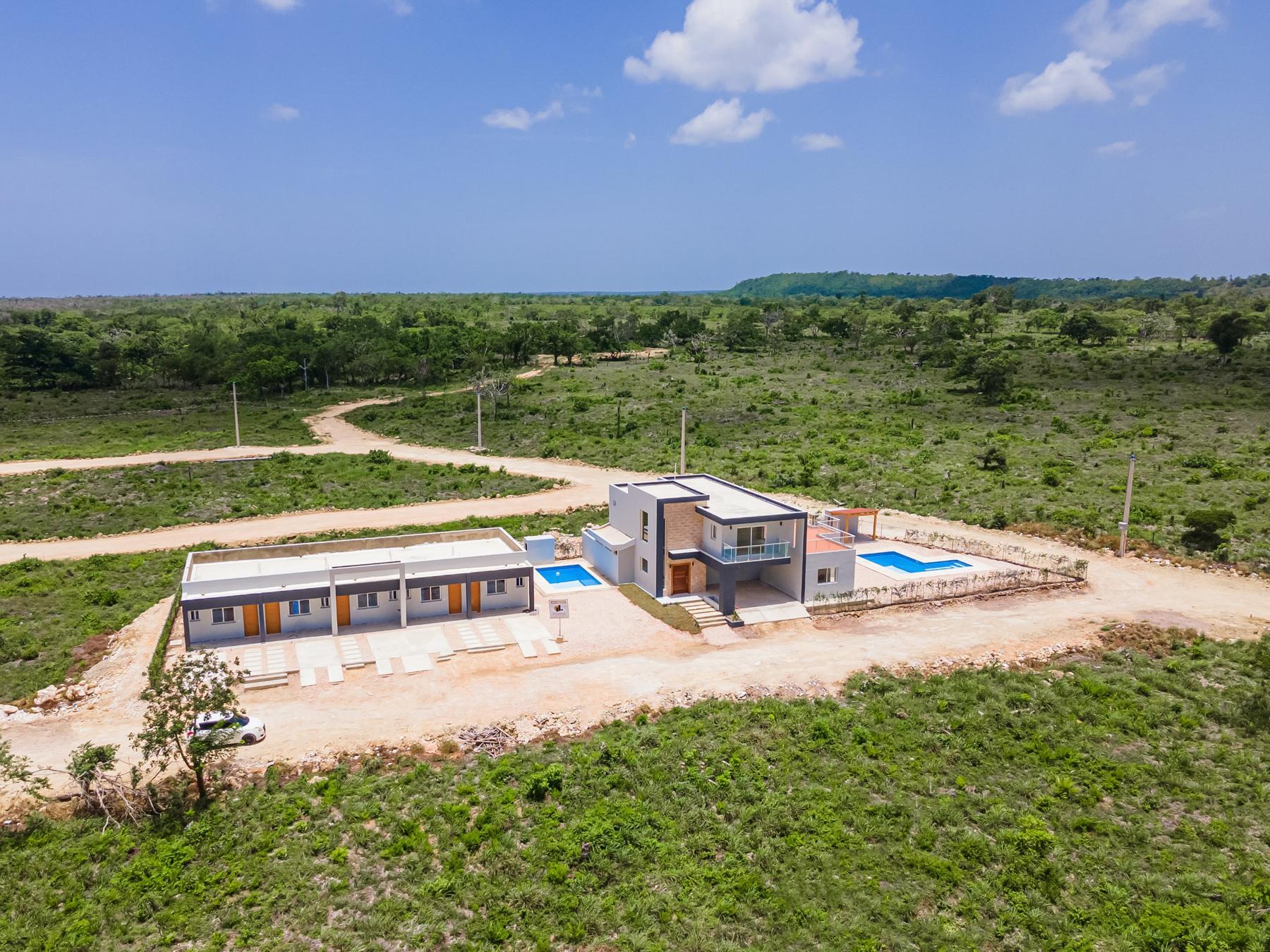 Vista aérea de villa y townhouses rodeados de vegetación