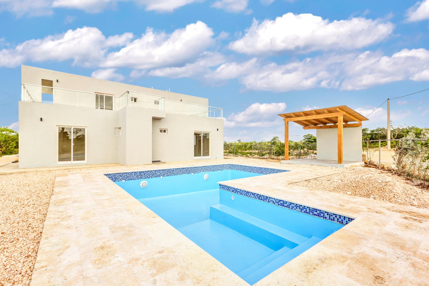 Piscina con bordes de piedra coralina y pérgola de madera